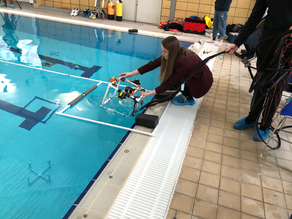 school children placing an ROV in the swimming pool