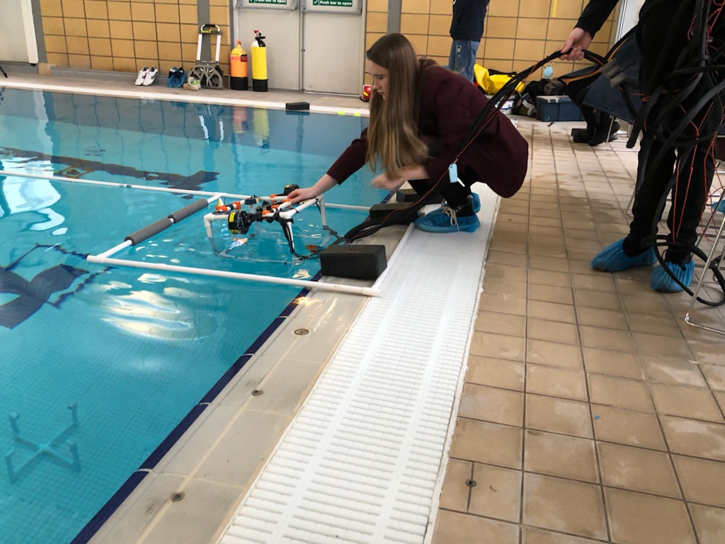 school children placing an ROV in the swimming pool