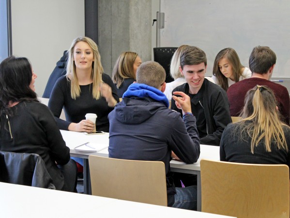 students sitting chatting at a table students sitting chatting at a table