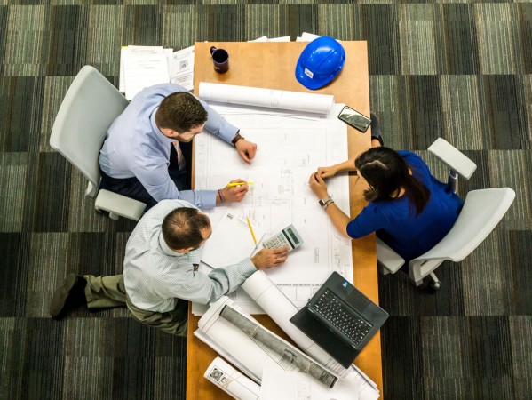 top view of people in a meeting over a desk top view of people in a meeting over a desk