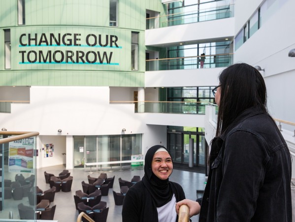 students in sir ian wood building smiling at each other
