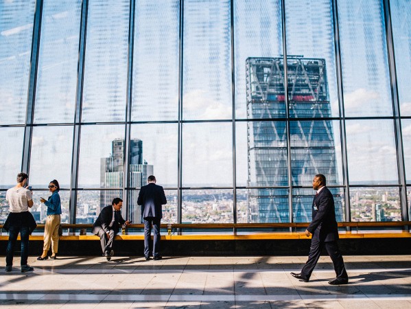 people looking out a window at a city skyline