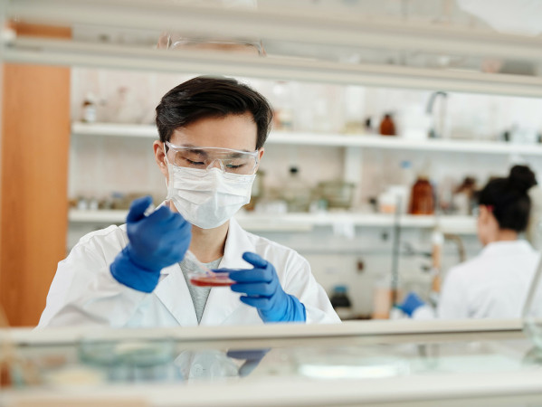 person wearing a mask in a lab using equiptment person wearing a mask in a lab using equiptment