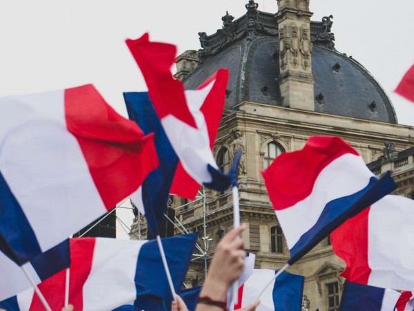 french flag flying in front of old building french flag flying in front of old building